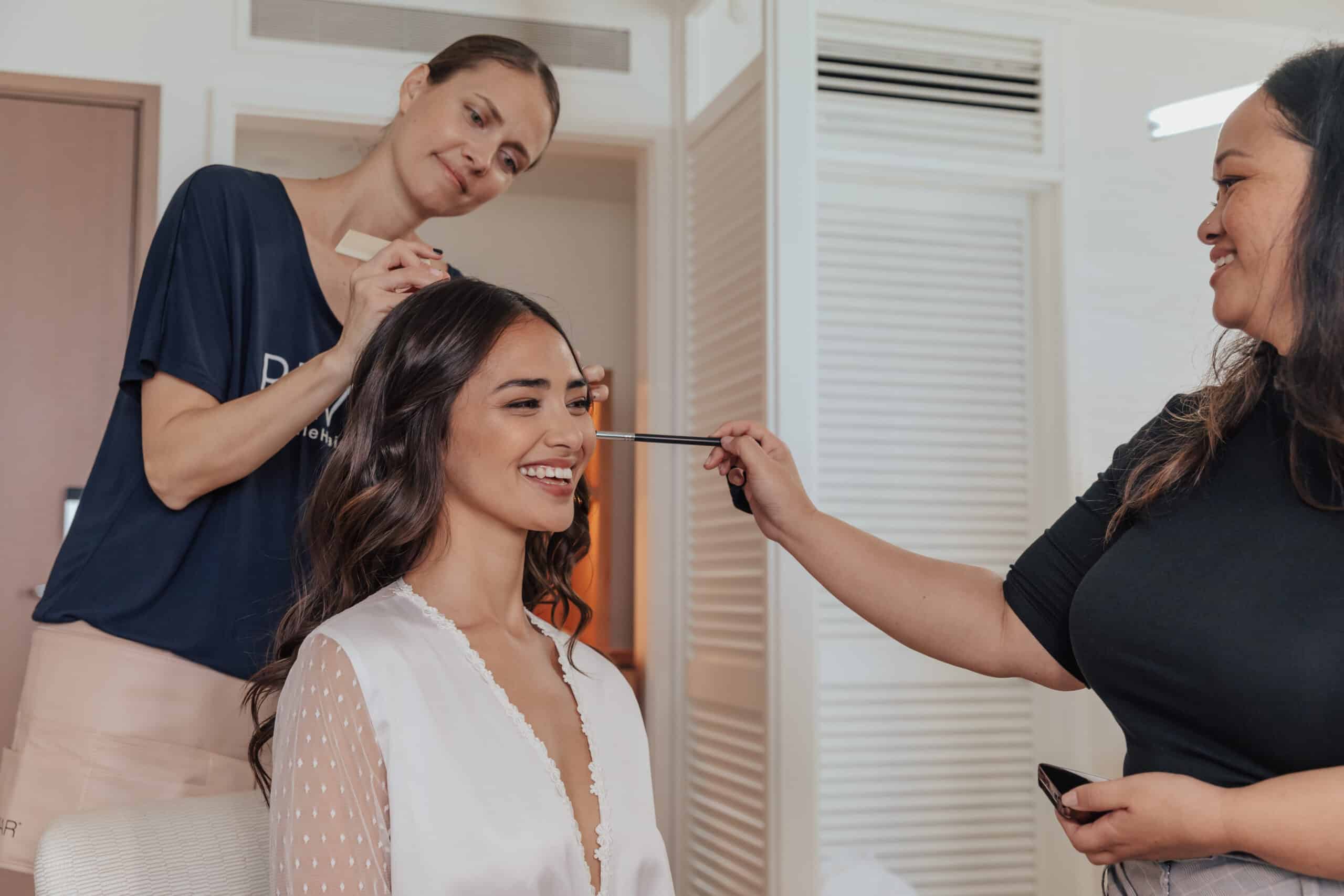 makeup artist and hair stylist doing a bride's hair and makeup
