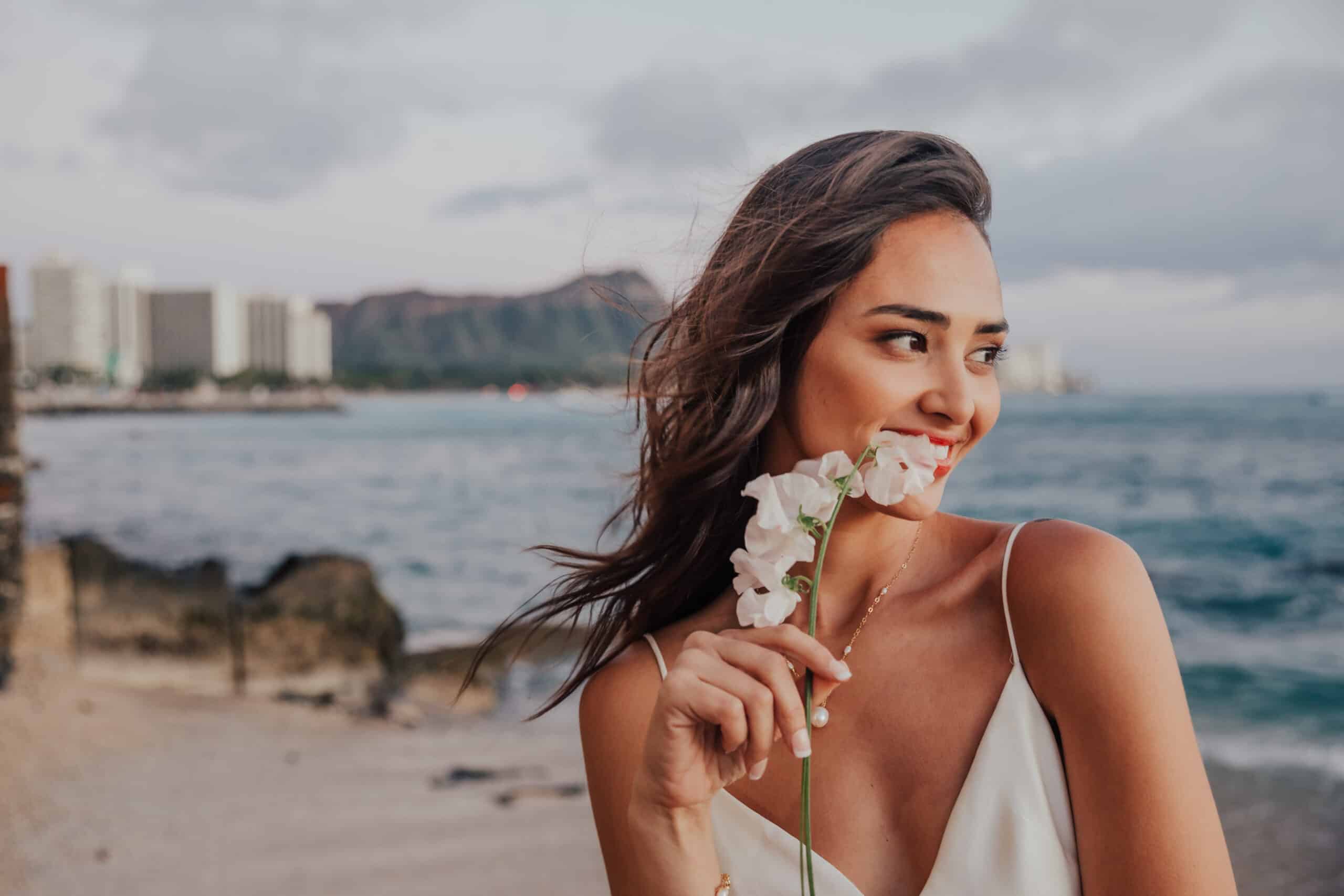 bride smiling with flowers on the beach