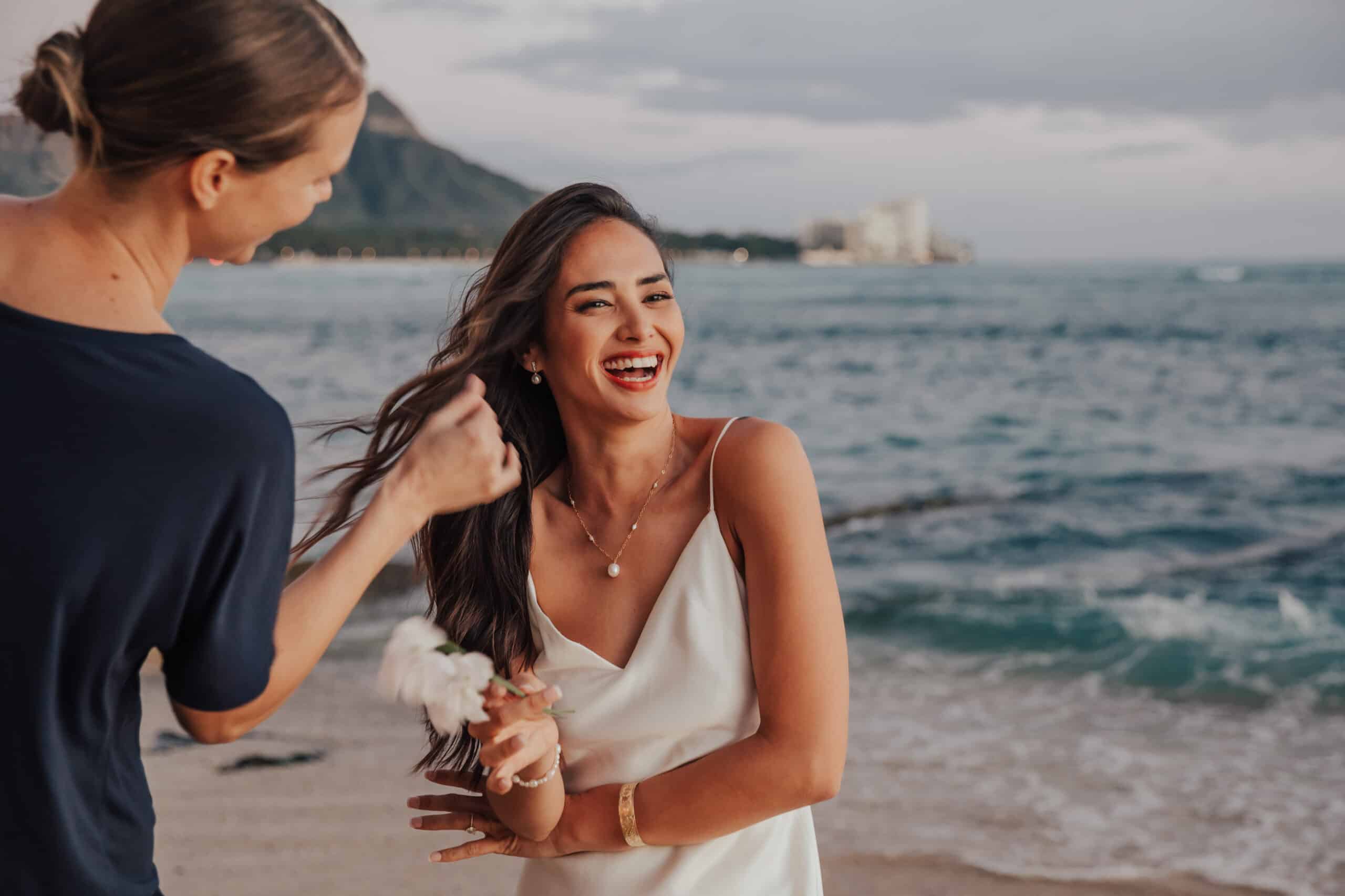 bride smiling while hair stylist is fixing hair