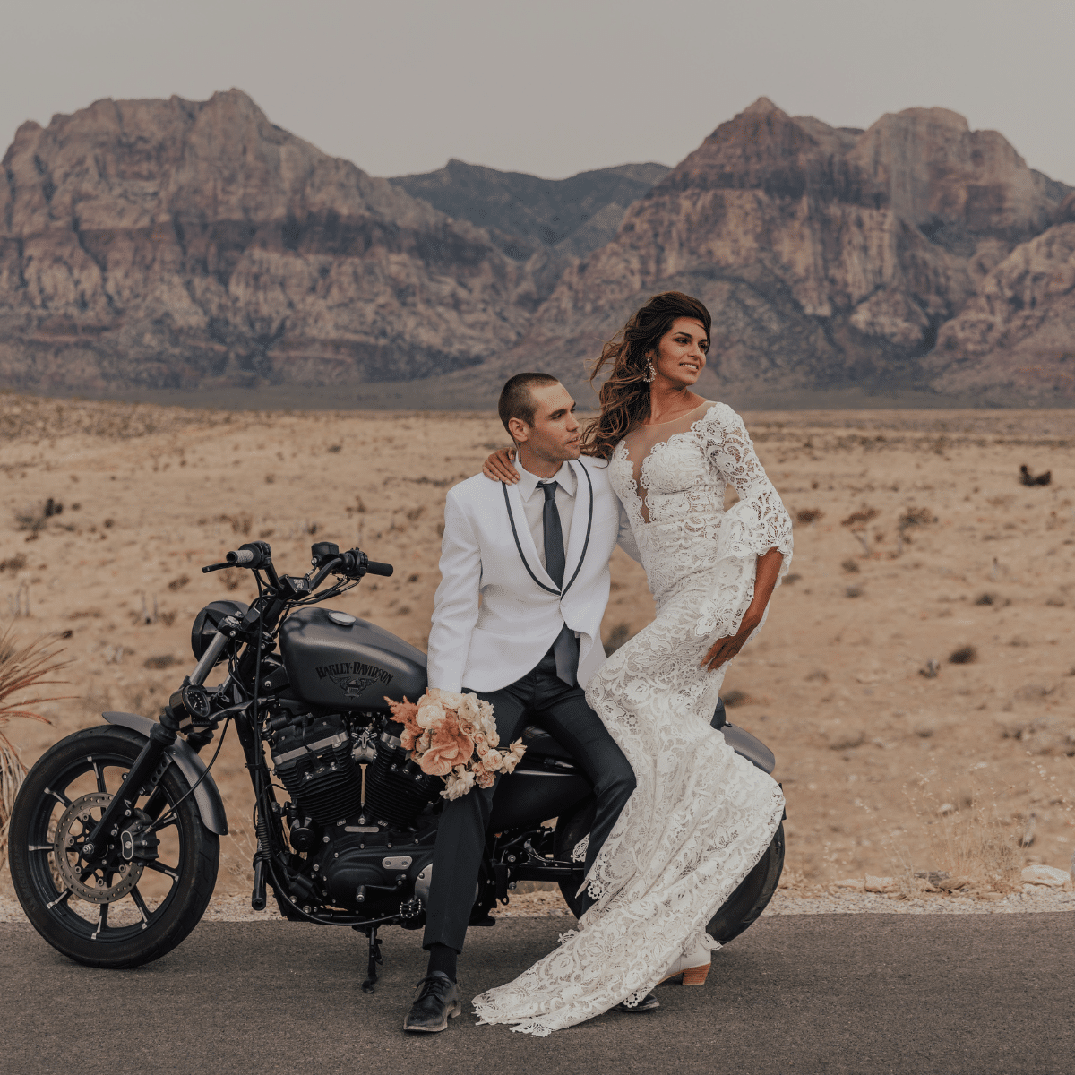 bride and groom in red rock park on a motorcycle